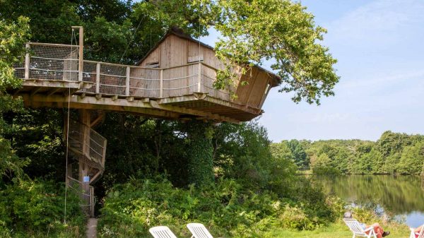 Cabane dans les arbres au bord de l'étang dans un camping Clef Verte