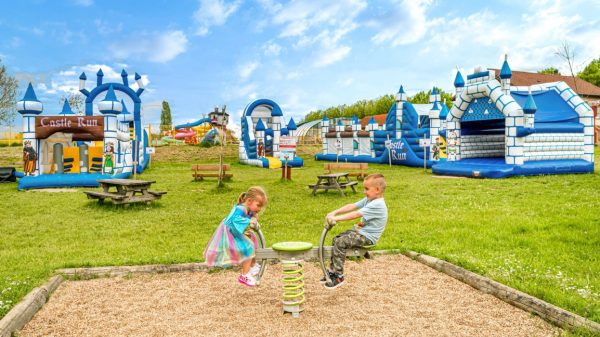 Balançoire devant les aires de jeux gonflables du camping