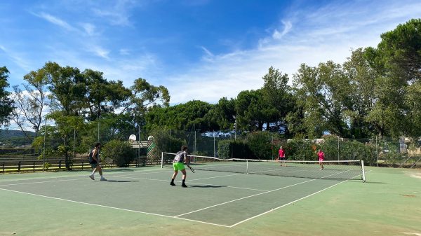 Jugar al tenis en el entorno natural del camping