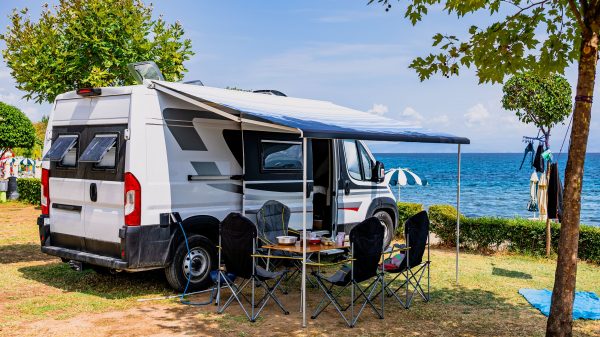 Wohnmobil mit ausziehbarem Vorzelt und Gartenmöbeln