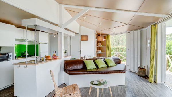 Le salon et la cuisine du chalet s'ouvrent sur une terrasse boisée